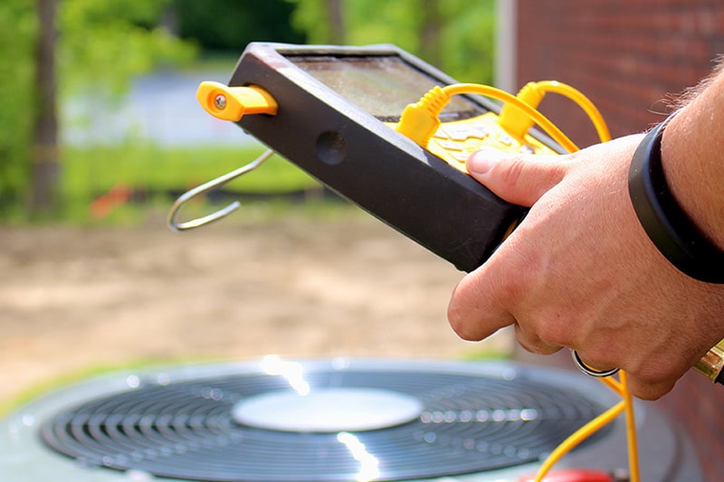 Why Is My AC Short Cycling? A technician fixing an air conditioning unit.